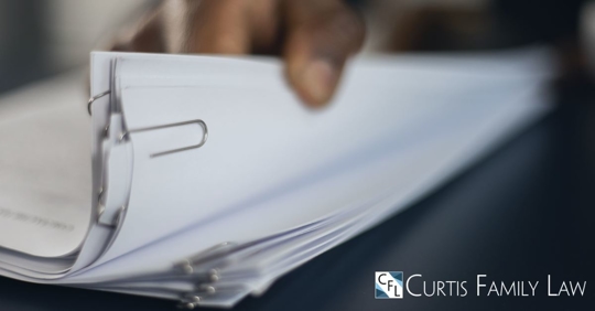 hand holding a stack of papers paperclipped together